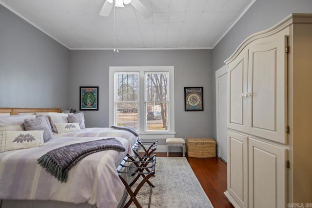 bedroom featuring dark wood-type flooring, ceiling fan, and ornamental molding