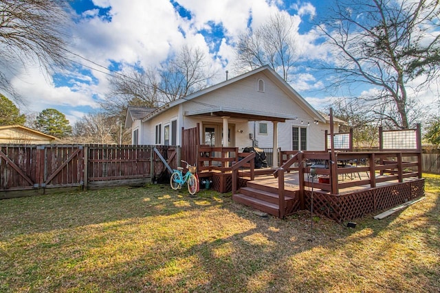 back of house featuring a wooden deck and a lawn