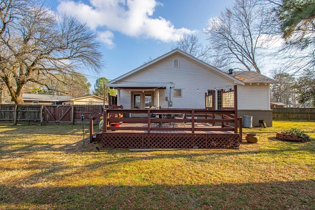 rear view of house with a wooden deck and a lawn