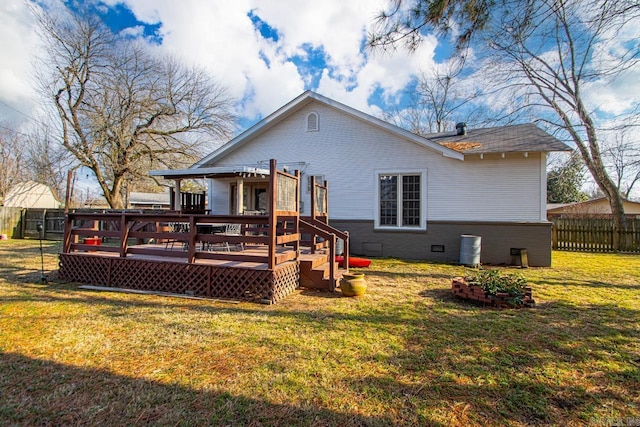 rear view of house featuring a wooden deck and a yard