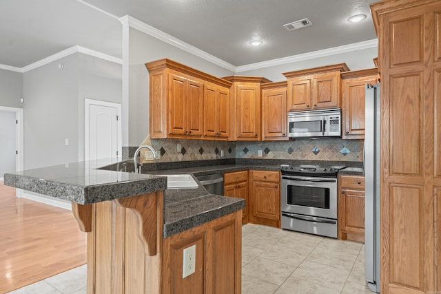 kitchen featuring sink, a breakfast bar area, crown molding, appliances with stainless steel finishes, and kitchen peninsula