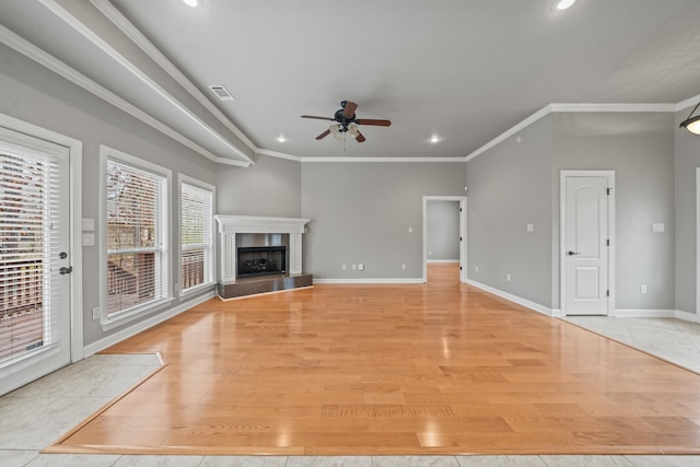 unfurnished living room with ceiling fan, light wood-type flooring, crown molding, and a fireplace