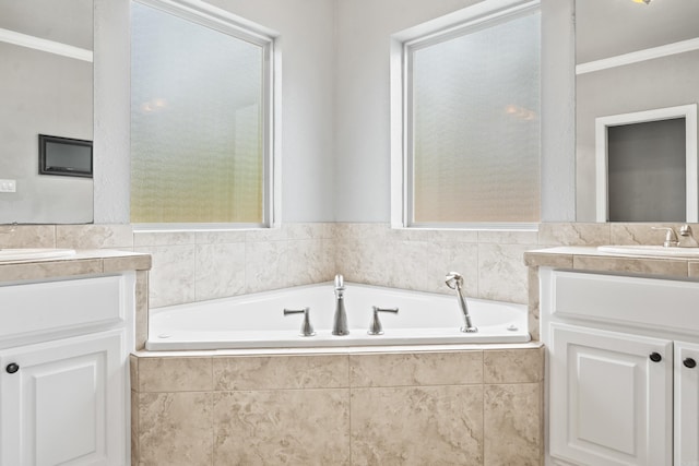 bathroom with a relaxing tiled tub, vanity, and crown molding