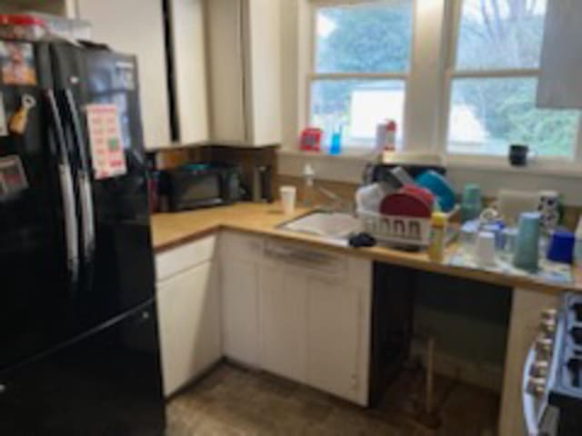 kitchen featuring white cabinets and black appliances