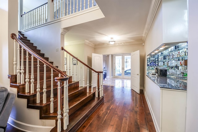 stairway with crown molding, bar, french doors, and hardwood / wood-style flooring