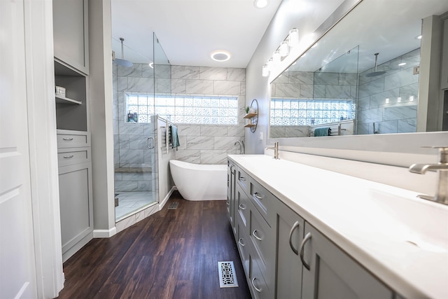 bathroom featuring hardwood / wood-style flooring, vanity, independent shower and bath, and tile walls