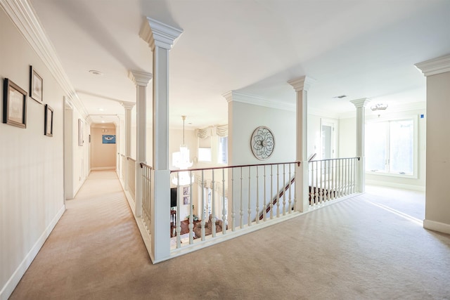 corridor featuring decorative columns, crown molding, plenty of natural light, and light carpet