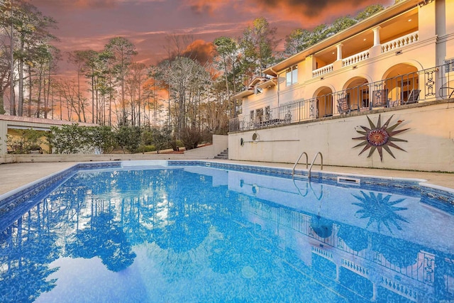 view of pool at dusk