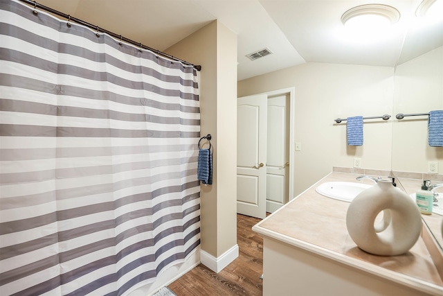 bathroom featuring vaulted ceiling, vanity, and hardwood / wood-style floors