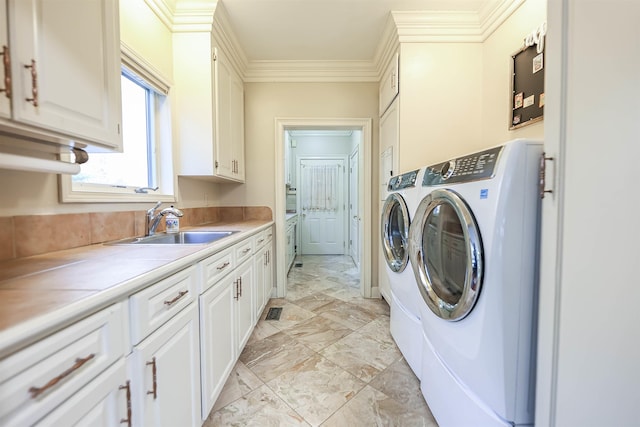 laundry room with separate washer and dryer, sink, crown molding, and cabinets