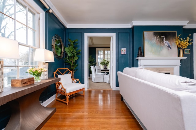 living room with crown molding and light hardwood / wood-style floors