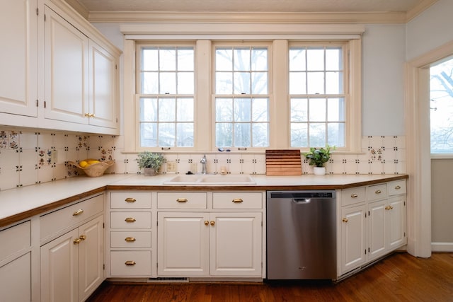 kitchen with tasteful backsplash, sink, white cabinets, stainless steel dishwasher, and crown molding