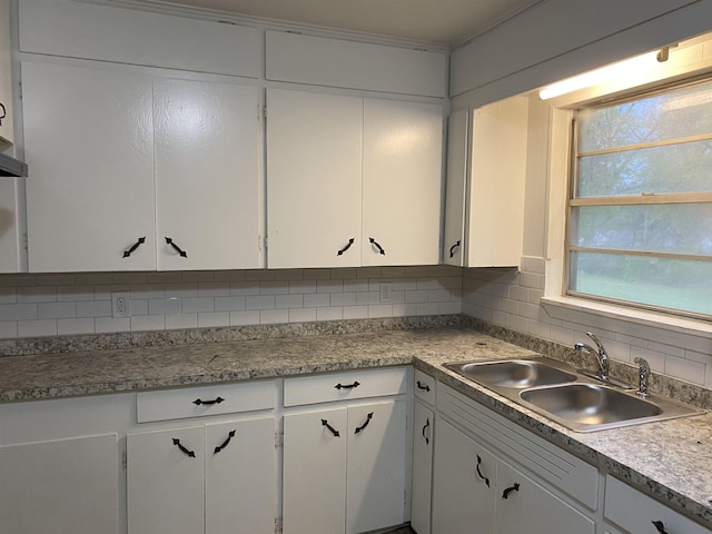 kitchen featuring sink, decorative backsplash, and white cabinets