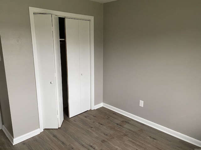 unfurnished bedroom featuring dark hardwood / wood-style floors and a closet