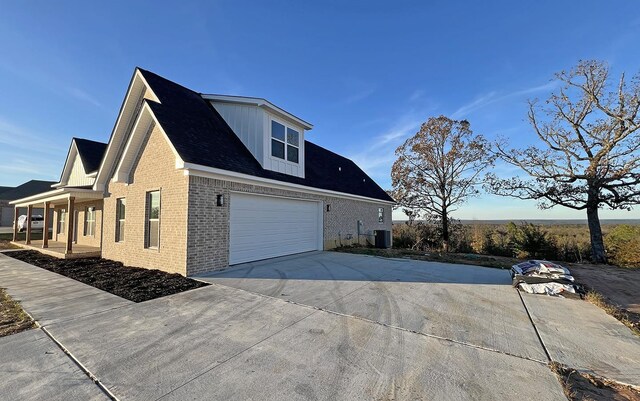 view of side of home featuring central AC unit and a garage