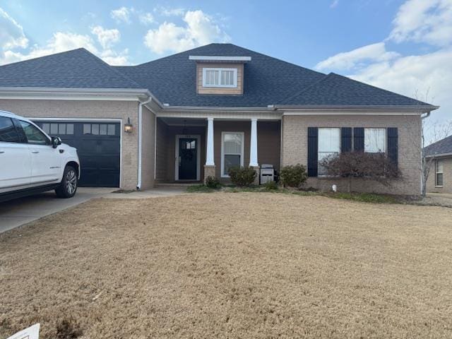 view of front facade featuring a garage, a front lawn, and roof with shingles