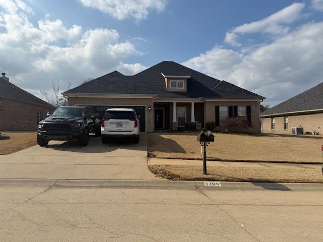 view of front of home featuring a garage and central air condition unit