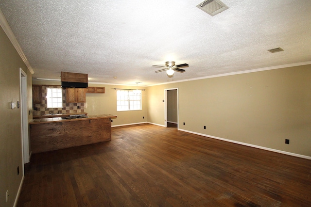 unfurnished living room featuring ornamental molding, dark wood-type flooring, a textured ceiling, and ceiling fan