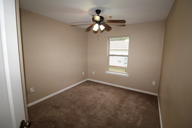 spare room featuring ceiling fan and dark colored carpet