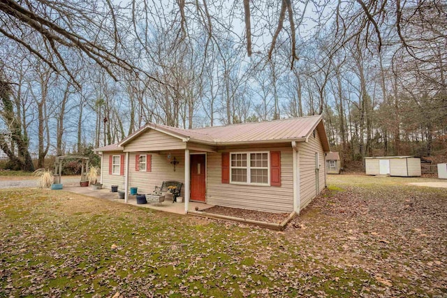 view of front of property with a patio area, a front yard, and a storage unit