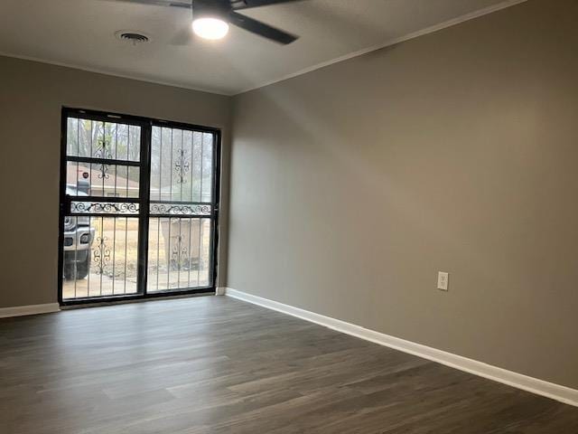 empty room featuring ceiling fan, crown molding, and dark hardwood / wood-style flooring