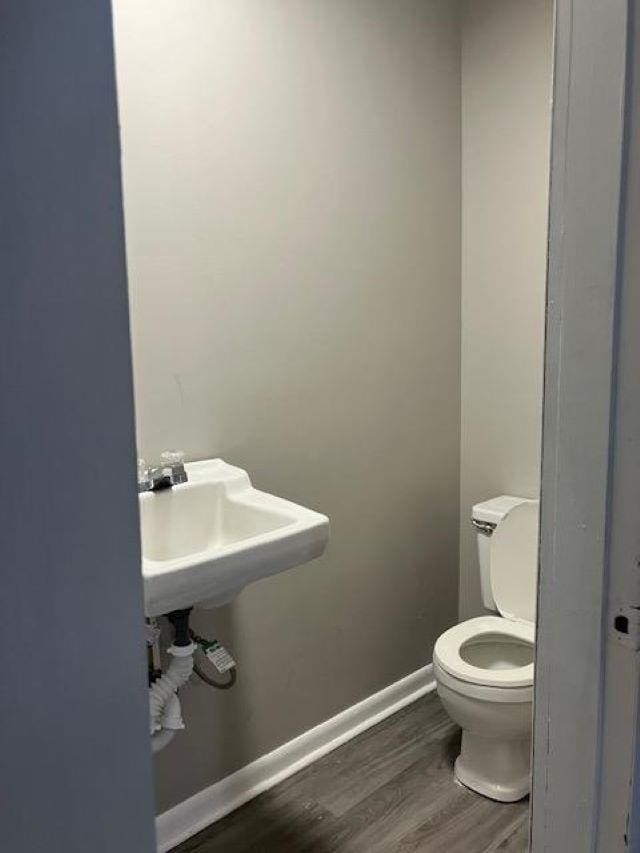 bathroom featuring wood-type flooring and toilet