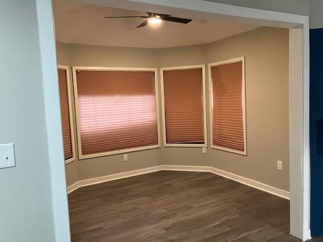 unfurnished room featuring dark wood-type flooring and ceiling fan