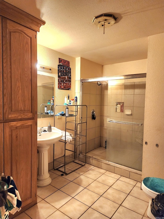 bathroom featuring an enclosed shower, tile patterned floors, and a textured ceiling