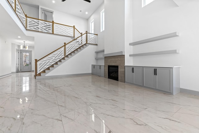 unfurnished living room featuring a high ceiling and ceiling fan