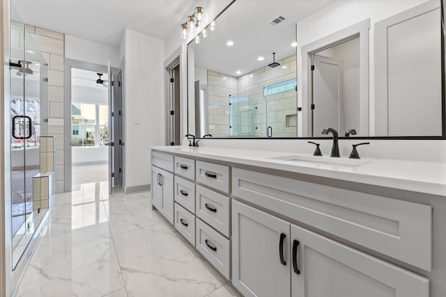 bathroom with vanity, a shower with shower door, and ceiling fan