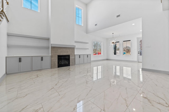 unfurnished living room featuring a high ceiling and a notable chandelier