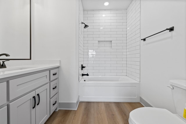 full bathroom with vanity, hardwood / wood-style floors, toilet, and tiled shower / bath