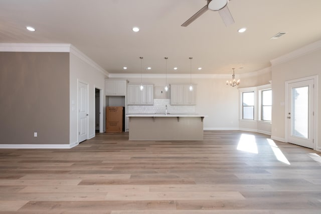 unfurnished living room with sink, ceiling fan with notable chandelier, ornamental molding, and light wood-type flooring