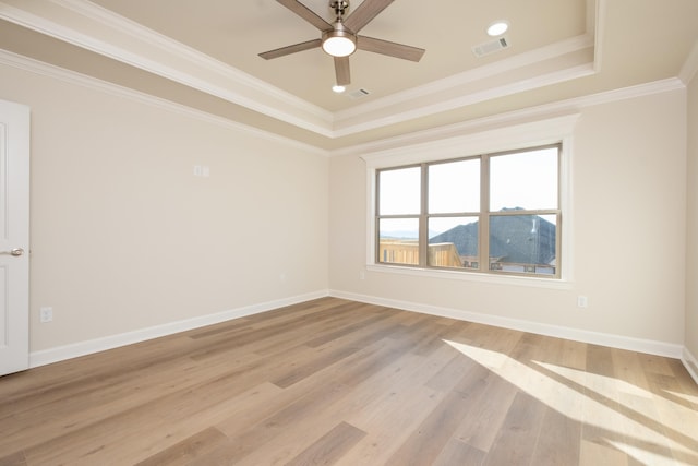 unfurnished room with a tray ceiling, ornamental molding, light hardwood / wood-style floors, and ceiling fan