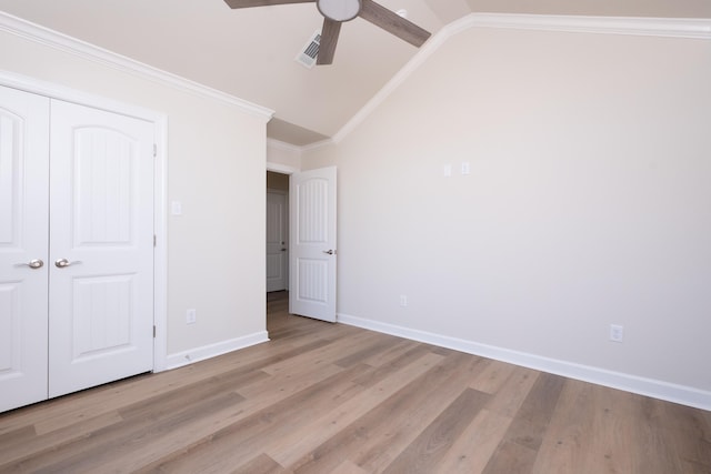 unfurnished bedroom with crown molding, vaulted ceiling, light wood-type flooring, a closet, and ceiling fan