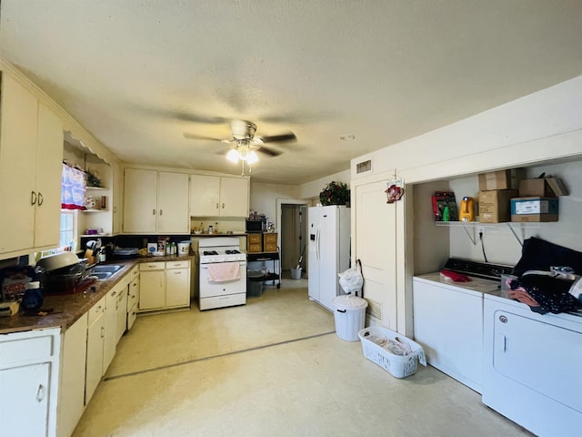 kitchen with sink, white appliances, ceiling fan, white cabinetry, and separate washer and dryer