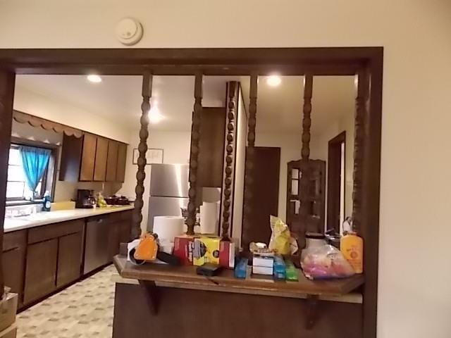 interior space featuring stainless steel refrigerator and dark brown cabinetry