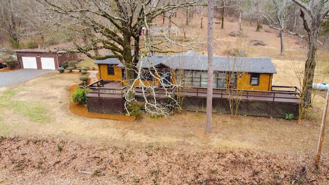 back of property featuring an outbuilding, a garage, and a deck