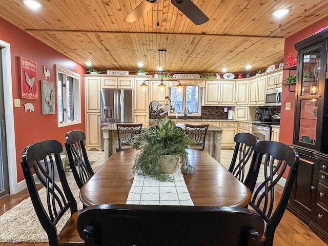 dining space featuring ceiling fan, light hardwood / wood-style floors, sink, and wooden ceiling