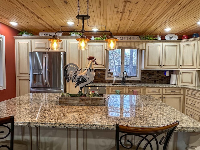 kitchen with a kitchen island, appliances with stainless steel finishes, a breakfast bar, and pendant lighting