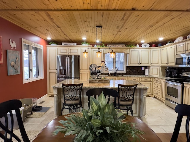 kitchen with a kitchen island, appliances with stainless steel finishes, sink, hanging light fixtures, and light stone counters