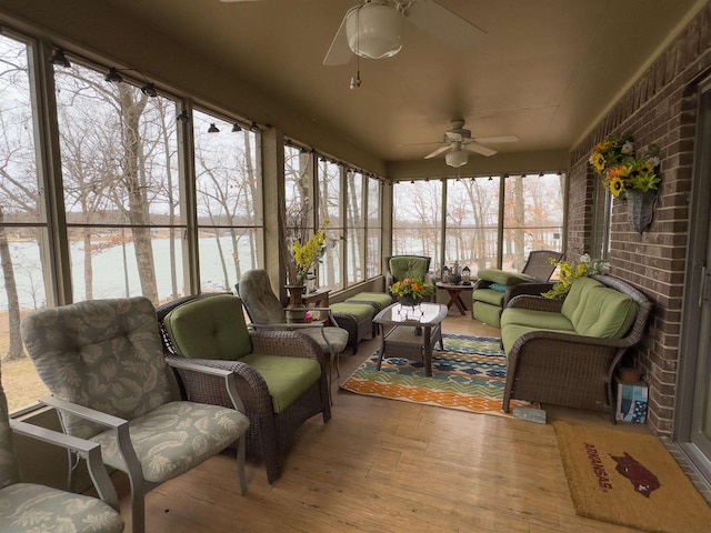 sunroom / solarium featuring a water view and ceiling fan