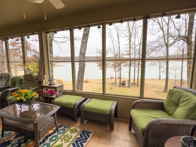 sunroom / solarium featuring a water view, ceiling fan, and a wealth of natural light