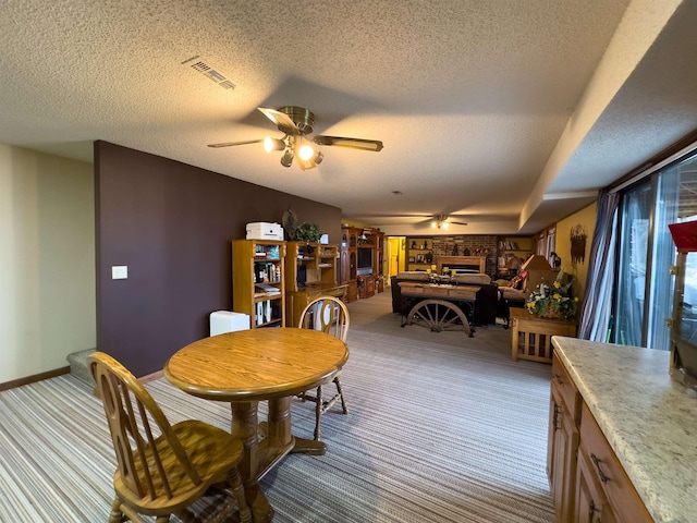 dining space with light carpet, a textured ceiling, and ceiling fan