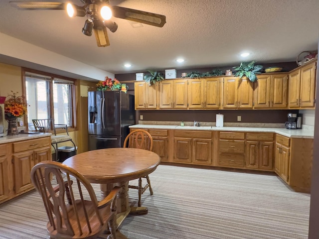 kitchen with sink, light colored carpet, black refrigerator with ice dispenser, a textured ceiling, and ceiling fan