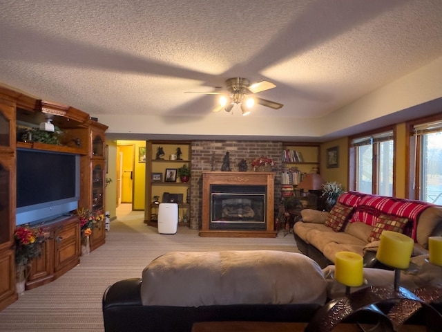 living room with light carpet, ceiling fan, a fireplace, and a textured ceiling