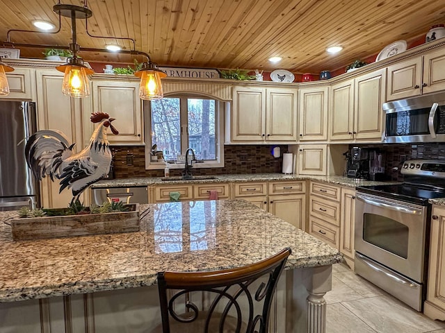 kitchen featuring a breakfast bar, sink, hanging light fixtures, light stone counters, and stainless steel appliances