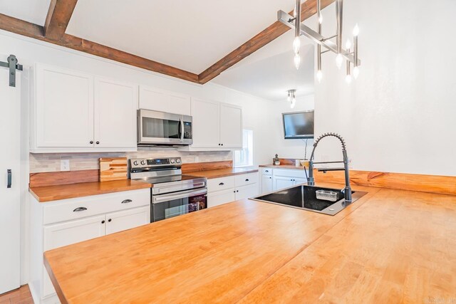 kitchen with white cabinetry, sink, wood counters, and stainless steel appliances