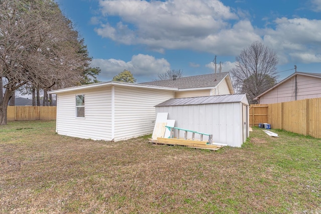 rear view of property with a shed and a lawn