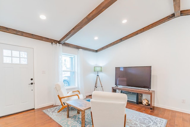 living room with vaulted ceiling with beams and light wood-type flooring